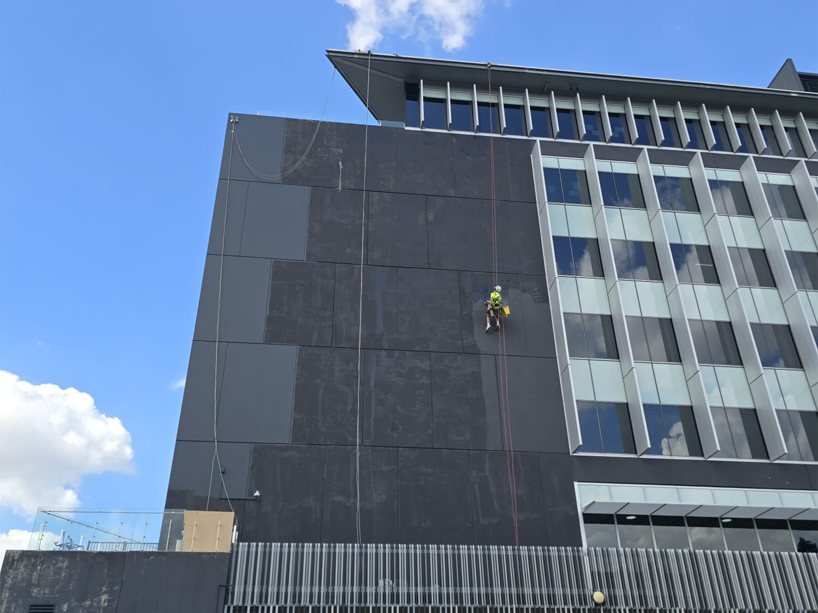 Painter working on a Brisbane building exterior on a clear dry day