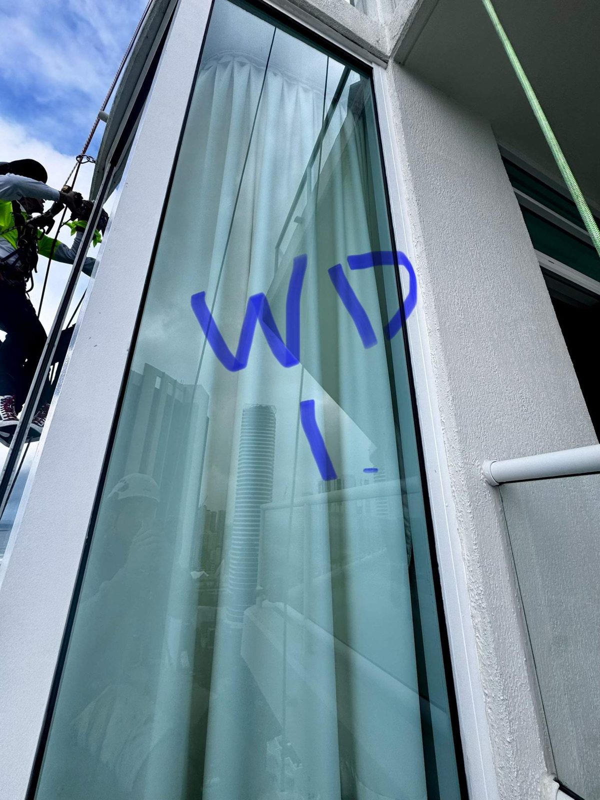 McAuliffe Painting rope access technician sealing the curtain wall at Carmel by the Sea, Broadbeach